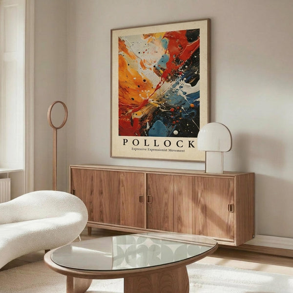 May include: Framed Jackson Pollock abstract expressionist art print hanging above wooden sideboard in modern living room. Colorful splattered paint design features vibrant oranges, reds, blues, and black against cream background. Room shows white curved chair, glass oval coffee table, floor lamp, and white walls with natural lighting.