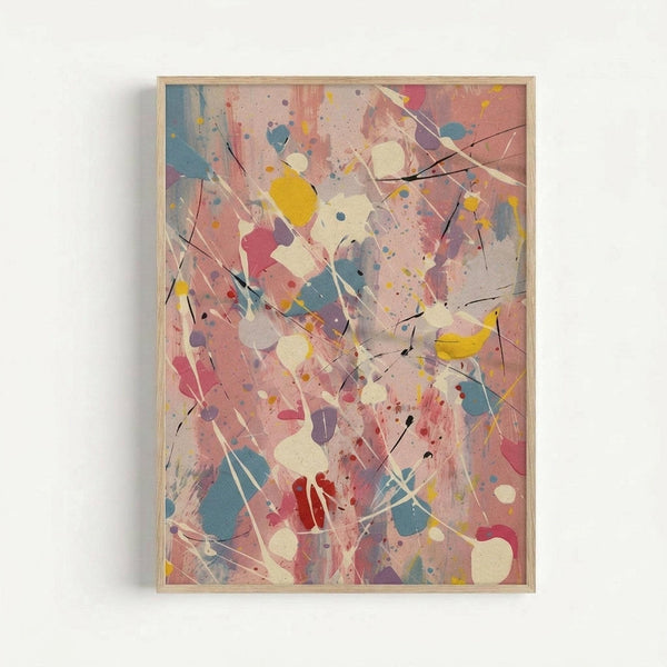 Framed abstract expressionist artwork featuring energetic paint splatters and drips in pink, blue, yellow, red, and cream colors across a light background. Black linear marks and gestural brushstrokes create dynamic movement throughout the composition. The piece is displayed in a natural wood frame against a white wall, showcasing the spontaneous, action-painting style with layered paint textures and scattered dots of various sizes.
