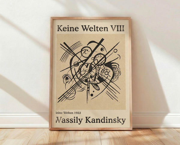 May include: Framed abstract art print with black line drawing on beige background, featuring intersecting curved and straight lines forming dynamic geometric composition. Wooden frame sits on light wood floor against white wall with soft natural lighting and shadows. Print shows "Keine Welten VIII" at top and "Wassily Kandinsky" at bottom in dark text.