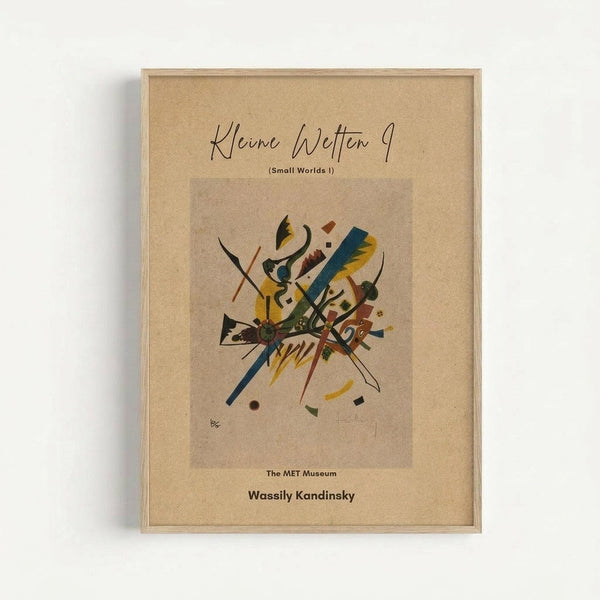 Framed abstract art print featuring geometric shapes and bold lines in yellow, blue, red, and black on cream background. The artwork shows Kandinsky's distinctive abstract style with intersecting angular forms and curved elements. Text at top reads "Kleine Welten 9 (Small Worlds I)" with "The MET Museum" and "Wassily Kandinsky" at bottom. Light wood frame against white wall.