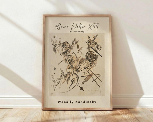 May include: Framed art print in natural wood frame leaning against white wall on light wooden floor. The vintage-style poster features abstract black ink drawings with geometric shapes, flowing lines, and organic forms on cream-colored paper. Soft natural lighting creates diagonal shadows across the minimalist room setting.