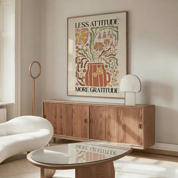 May include: Vintage-style poster with large orange ceramic vase and colorful floral arrangement, displayed above wooden mid-century credenza in modern living room. White sculptural chair and glass coffee table visible. Poster features retro botanical illustration in warm autumn tones of orange, brown, and green against cream background in thin wooden frame.