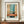 May include: Framed abstract art print in warm wooden frame displayed on mid-century walnut credenza against cream paneled wall. Artwork features soft color blocks in turquoise, coral orange, cream and navy with Mark Rothko attribution text below. Small white ceramic vase and stacked books flank the frame. Natural lighting creates gentle shadows on the textured painted surface.