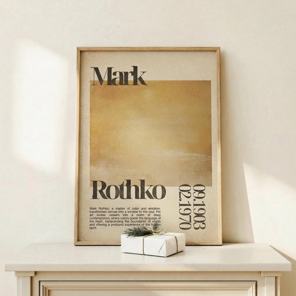 May include: Framed Mark Rothko exhibition poster with warm golden-yellow rectangular color field, displayed on light wood surface against cream wall. Small wrapped gift box with twine sits beside the natural wood frame. Poster features black typography and descriptive text about the artist's emotional use of color.