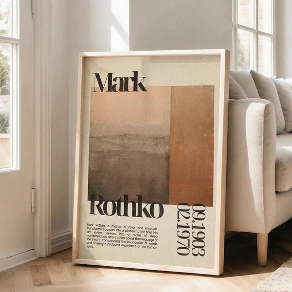 May include: Framed art print leaning against white wall next to beige sofa in bright living room. Poster features abstract brown and orange rectangular color blocks with "Mark Rothko" text and biographical information. Light wood frame, natural lighting from large windows, hardwood floors visible.