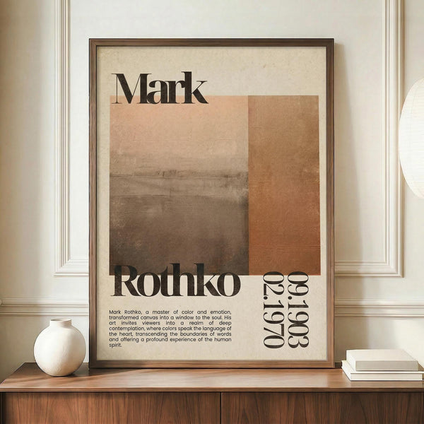 May include: Framed poster with Mark Rothko's name in large black serif letters above abstract geometric blocks in warm brown and orange tones. Features biographical text and birth-death years 1903-1970 in vertical typography. Displayed on wooden sideboard next to white ceramic vase and stacked books against cream walls with white trim molding.