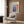 a living room with a white armchair, a floor lamp, and a framed poster on the wall.