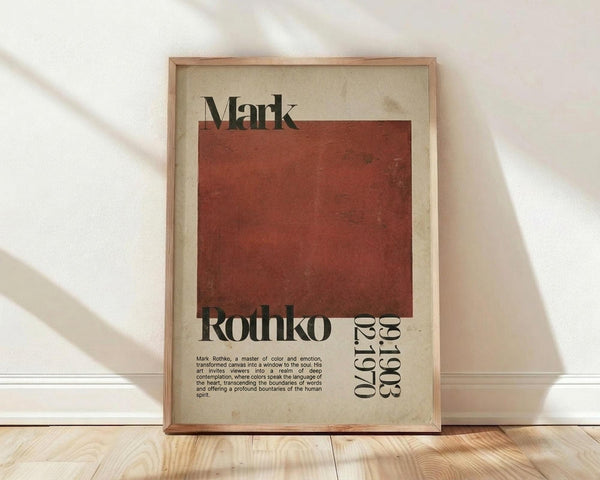 May include: Framed vintage-style art poster with cream background featuring large rusty red square, black text reading "Mark Rothko" and exhibition details "02.19 03.19", descriptive paragraph below. Natural wood frame displayed on light wooden floor against white textured wall with soft window light shadows.