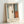 May include: Framed abstract art print in light wood frame leaning against white wall. Artwork features soft blue-gray background with vertical white and dark brown brushstrokes, orange rectangular shape in lower right. French text below image reads "L'abstraction émotionnelle à la manière de Mark Rothko" with "MARK ROTHKO" in large letters. Minimalist interior setting with natural lighting casting gentle shadows.