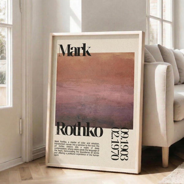 May include: Framed art print leaning against white wall next to beige sofa in bright living room with large windows. Print features abstract color gradient from cream to deep purple with "Mark Rothko" text and descriptive paragraph below. Light wood frame, approximately 2-3 feet tall, creates warm shadows on wooden floor.