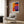 a modern living room with a white armchair, a floor lamp, and a large abstract painting on the wall.