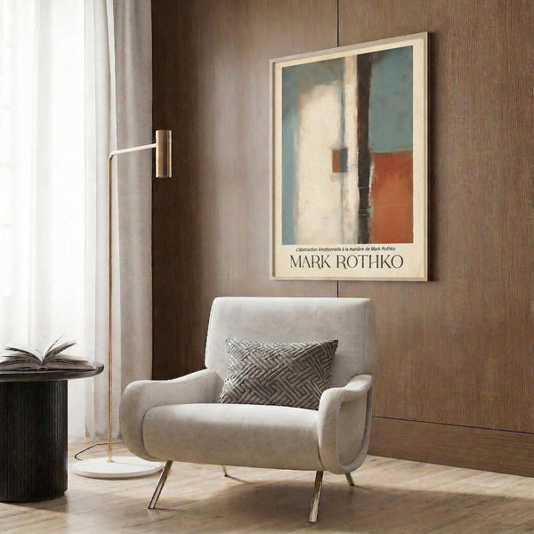 a modern living room with a white armchair, a floor lamp, and a framed abstract painting on the wall.