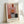 May include: Framed abstract art print in light wood frame leaning against white wall. Artwork features geometric blocks of color including soft pink, coral, orange, gray, and dark green sections with painterly brushstroke texture. French text below reads "L'apatoration émotionnelle à la mambre de Mark Rothko" and "MARK ROTHKO" in serif font. Natural lighting creates subtle shadows on wall.
