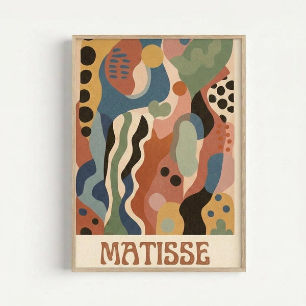 Abstract artwork in natural wood frame featuring organic flowing shapes and patterns in muted colors including coral pink, sage green, navy blue, mustard yellow, cream and black. The composition includes wavy lines, circular dots, and curved forms that overlap and interweave throughout. Text reading "MATISSE" appears at the bottom in brown letters. The framed piece is displayed against a light gray wall.