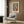 May include: Colorful abstract art poster with organic shapes in coral, blue, green, and orange tones, featuring "MATISSE" text below the artwork. Displayed in light wood frame on wood-paneled wall above cream armchair with geometric pillow. Modern room setting with brass floor lamp and side table.