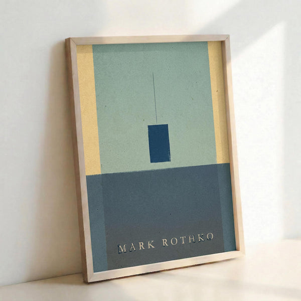 May include: Framed poster print in natural wood frame leaning against white wall. Abstract minimalist artwork features geometric color blocks - pale mint green upper section with yellow vertical strip on left, small dark blue rectangle in center, and darker blue-gray lower section. Artist name "MARK ROTHKO" printed in small serif text at bottom right. Modern contemporary art style with clean lines and muted color palette.