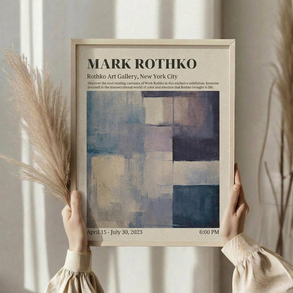 May include: Person in cream sweater holding framed abstract art poster featuring soft rectangular color blocks in blues, purples, and neutrals, with dried wheat stems beside window with natural lighting