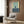 a modern living room with a white armchair, a floor lamp, and a framed abstract art piece on the wall.