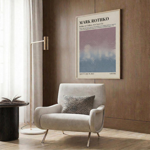 a modern living room with a white armchair, a floor lamp, and a framed poster on the wall.