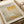 The image is a poster for an art exhibition titled "Mark Rothko" by the artist Mark Rothko. The poster features a large abstract painting with a geometric pattern in shades of yellow and beige. The event is scheduled to take place on April 15, 2023, at 6:00 PM.