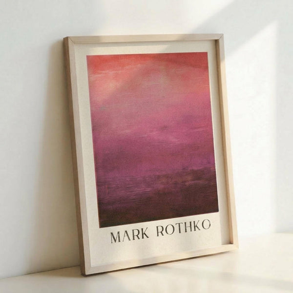 May include: Framed art print featuring abstract gradient from coral pink at top transitioning through magenta to deep burgundy at bottom, displayed in light wooden frame with white matting against white wall, leaning on surface with soft natural lighting creating subtle shadows