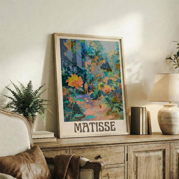 May include: Framed art print featuring vibrant tropical garden scene with colorful flowers, palm fronds, and foliage in blues, oranges, and greens, displayed on rustic wooden sideboard alongside fern plant, ceramic vase, and books in cozy living room setting with cream armchair and neutral walls.