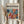 May include: Person in beige ruffled sleeves holding framed poster against white curtained window, with dried pampas grass visible to left. Poster features vibrant abstract cutout design in blues, oranges, pinks and yellows reminiscent of Matisse's paper collage style, with black text reading "matisse modernist" and event details above colorful botanical shapes in light wood frame.