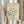 May include: Person in beige sweater holding framed poster featuring green coral-like abstract design on cream background, with "MATISSE PAPIERS DÉCOUPÉS" and French exhibition text. Dried pampas grass visible to left, soft natural lighting against white curtained window.