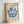 May include: Framed poster print featuring blue coral-like shapes arranged in a wreath pattern on cream background, with "MATISSE" at top and "BERGGRUEN & CIE" gallery text at bottom. Natural wood frame leaning against white wall, showing textured paper surface and exhibition details from Paris 1953.