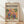 May include: Framed poster with colorful parrots perched on branches surrounded by tropical leaves in Matisse-inspired cut-out style. Features vibrant oranges, pinks, blues, and greens against warm yellow background. Text reads "matisse modernist" and "Embracing Colorful Freedom In the Spirit of Matisse" with event details. Natural wood frame displayed on light wooden floor against white wall with soft shadows.