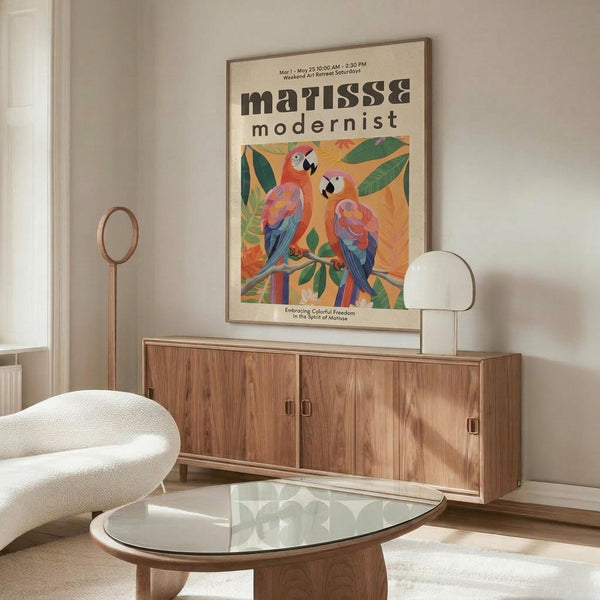 May include: Colorful modernist-style poster featuring two vibrant parrots perched on branches with tropical leaves, displayed in wooden frame above walnut credenza in minimalist living room. Cream upholstered chair and glass oval coffee table complete the mid-century modern setting with warm beige walls and natural lighting.