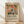 May include: Framed poster with colorful floral artwork featuring stylized flowers and leaves in orange, pink, green, and blue tones against a cream background. Bold black text below reads "Matisse: A Master of Color and Form" followed by smaller descriptive text about an art exhibition. Natural wood frame sits on light wooden floor against white textured wall with soft shadows.