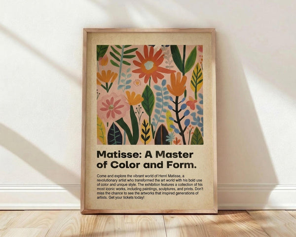 May include: Framed poster with colorful floral artwork featuring stylized flowers and leaves in orange, pink, green, and blue tones against a cream background. Bold black text below reads "Matisse: A Master of Color and Form" followed by smaller descriptive text about an art exhibition. Natural wood frame sits on light wooden floor against white textured wall with soft shadows.