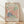 May include: Framed vintage exhibition poster featuring Matisse's cut-out paper artwork in coral pink, sage green, and navy blue organic leaf shapes against cream background. Light wood frame sits on blonde hardwood floor against white wall with soft natural lighting casting diagonal shadows.