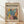 May include: Framed poster with colorful tropical leaves in Matisse-inspired cut-out style, featuring vibrant pink, teal, yellow, and orange foliage against cream background. Wooden frame leans against white wall on light wood floor with soft shadows.