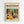 May include: Framed vintage-style poster featuring a colorful still life with wine bottle, glass, fruits including oranges and grapes, potted plants, and bowl of olives in bold, flat modernist art style with vibrant greens, oranges, and purples against cream background, displayed on white wall in light wood frame.