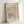 May include: Framed vintage Matisse exhibition poster featuring colorful paper cut-out leaf patterns in coral pink, sage green, and navy blue on cream background. Light wood frame displayed against white wall, showing gallery text for Berggruen & Cie Paris exhibition from 1953.