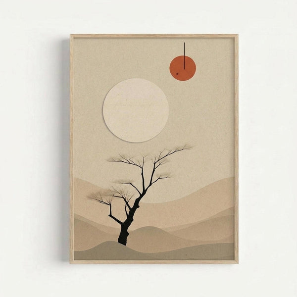 Framed minimalist desert artwork with beige and tan tones, featuring a bare black tree silhouette in rolling sand dune landscape. Two circles in upper portion - large pale moon and smaller orange sun with vertical line through it. Displayed in light wood frame against white wall.