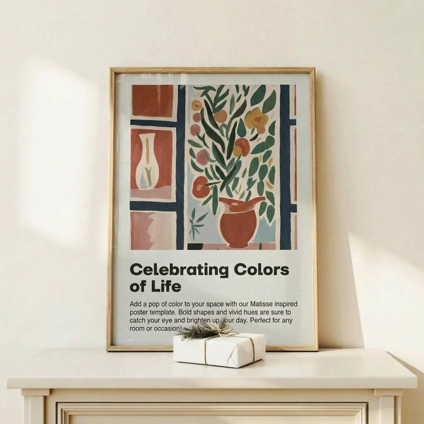 May include: Matisse-inspired poster in natural wood frame displaying colorful still life with potted plant, vases, and geometric shapes in terracotta, green, and blue tones. Text reads "Celebrating Colors of Life" with descriptive paragraph below. Frame sits on light wood surface next to small wrapped gift with twine and greenery sprig against cream wall.