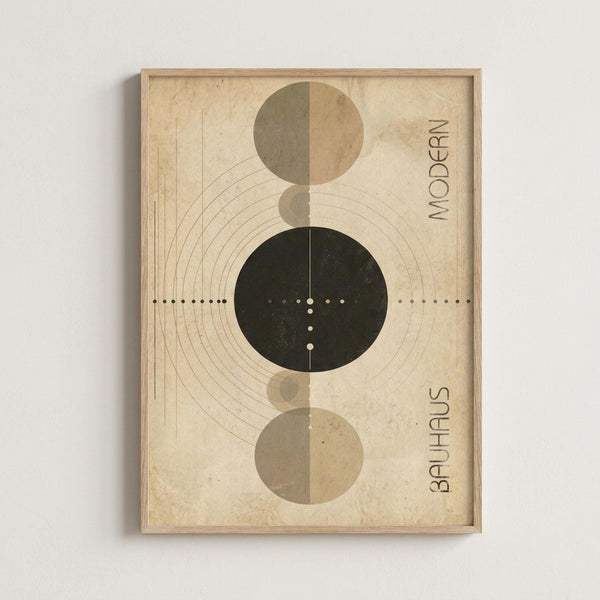 A geometric art print in a wooden frame features overlapping circles in earth tones - sage green, tan, and dark forest green - arranged vertically on an aged cream background. Concentric curved lines radiate from the circles, with dotted lines extending horizontally across the composition. The words "MODERN" and "BAUHAUS" appear vertically along the right edge. The framed artwork is mounted on a light gray wall.