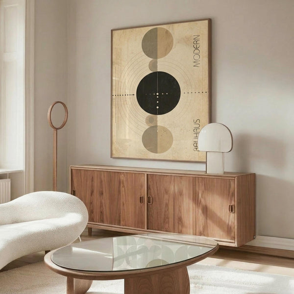 May include: Modern abstract art print featuring geometric circles and semi-circles in beige, olive green, and black tones with concentric line patterns and dotted elements, displayed in thin wooden frame above walnut credenza in minimalist living room with cream upholstered chair, glass coffee table, and contemporary lighting fixtures