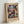 May include: Framed exhibition poster featuring Paul Klee's abstract artwork with colorful geometric squares and rectangles in blues, purples, pinks, and earth tones. The vintage-style poster shows museum text and sits in a light wooden frame leaning against a white wall on a white surface.