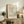 May include: Framed Matisse art print displayed on rustic wooden sideboard in warm-toned living room. Print features abstract cut-out shapes in coral, sage green, and cream with crosshatched and dotted patterns. Natural wood frame complements fern plant, stacked books, ceramic vase, and cream upholstered furniture visible in cozy interior setting.