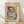 May include: Framed poster print in light wood frame featuring cubist-style portrait of woman with geometric facial features in blue, green, yellow and orange tones. French text below artwork reads about contemporary artistic creations inspired by Picasso's techniques. Frame leans against white wall on light wooden floor with soft natural lighting creating diagonal shadows.