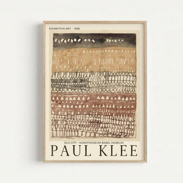 May include: Framed vintage exhibition poster featuring Paul Klee's abstract artwork with horizontal bands of geometric patterns in earth tones - browns, tans, and black. The piece displays repetitive triangular shapes, lines, dots, and crosshatch textures arranged in decorative rows. Text indicates it's from a 1928 exhibition at Kunstmuseum Basel Museum. The poster is displayed in a light wooden frame against a white wall.