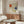 May include: Piet Mondrian art print displayed above wooden sideboard in modern living room with white curved chair, glass coffee table, and minimalist decor. Abstract geometric artwork features grid lines with red, blue, and yellow color blocks on cream background in thin frame.