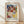 May include: Framed exhibition poster featuring Paul Klee's abstract watercolor artwork from 1914, displayed against a white wall on wooden flooring. The artwork shows geometric patches in blues, reds, yellows, greens, and earth tones with various textures and patterns. Natural light creates soft shadows across the scene. The poster has museum exhibition text and the artist's name in bold letters below the colorful abstract composition.