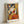 May include: Framed cubist-style artwork featuring a seated woman with black hair holding a fan, rendered in geometric shapes with orange, yellow, white, and gray tones. The print displays "PICASSO" text at bottom with French description. Light wood frame leans against white wall on white surface.