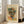 May include: Framed vintage-style poster featuring a cubist portrait with geometric face in vibrant blues, oranges, greens, and yellows against cream background, displayed on light wood floor beside beige armchair near white-framed windows in bright living room setting.