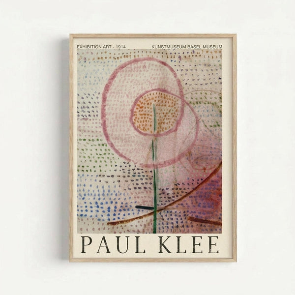 Paul Klee abstract artwork featuring a dotted pattern background in blues, greens, and purples with overlapping pink circular forms and a central orange circle containing a green vertical line. Dark angular shapes cross the bottom portion. The piece is displayed in a light wooden frame against a white wall, showing the museum exhibition poster format with text at top and bottom.